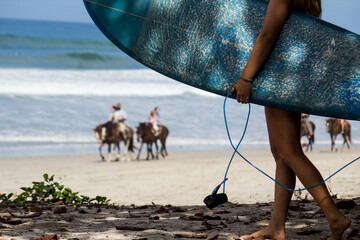 person on the beach with horse and surfboard surfing Costa Rica Santa Teresa Nosara