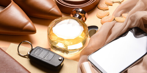 Set of stylish female accessories with mobile phone, car key and perfume bottle on table