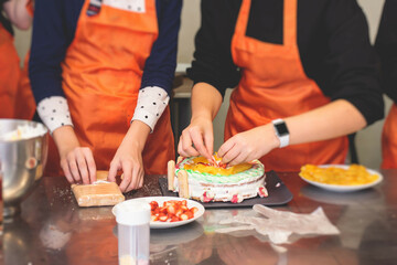 Group of children in a cooking class, kids preparing asian style food in the kitchen together, kids in aprons learn cooking on master class, chef uniform, hands in gloves