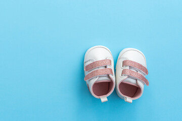 Baby shoes on paper background with copy space. Baby clothes concept. Top view, flat lay