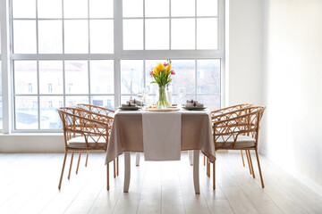 Beautiful table setting for International Women's Day celebration with tulip flowers in light room near window