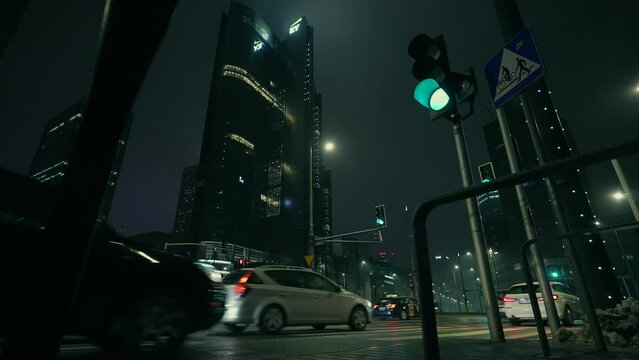 NIght view of city downtown district of Warsaw at rain. Night life. Streets and skyscrapers. Cars and public transport. Rainy foggy weather in the night city. Gotham city mood. Cyberpunk, cinematic 