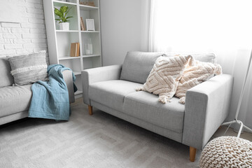 Grey sofa with cushions in interior of living room
