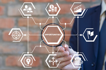 Businessman holding magnifying glass and working on virtual touchscreen of future sees text: OPPORTUNITIES. Concept of opportunities success business career. Search new opportunities.