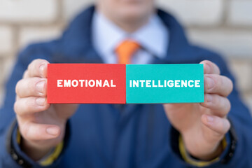 Businessman holding colorful blocks with inscription: EMOTIONAL INTELLIGENCE. Concept of Emotional...