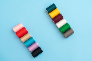 Contrasting several colored spools of sewing thread as a concept of different people in one common cause