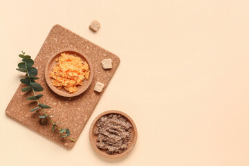 Composition with plates of body scrub, cane sugar and eucalyptus branch on color background