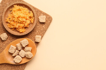 Plate of body scrub and cane sugar on color background