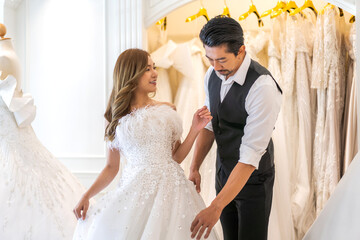 Fototapeta premium Portrait of smiling cheerful happy love asian couple fashion bride man and woman posing in white wedding dress for pre wedding hug together at wedding interior fashion studio