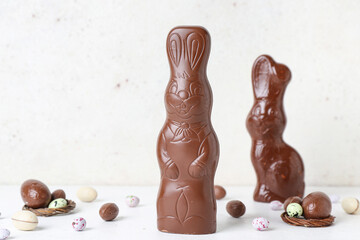 Chocolate Easter bunnies with eggs on white background