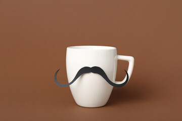 Cup with paper mustache on color background. Father's Day celebration