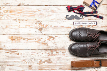 Composition with stylish male shoes and accessories on light wooden background. Father's Day celebration