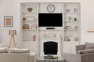 Fototapeta na wymiar Cozy room interior with stylish furniture, decorative fireplace and TV set