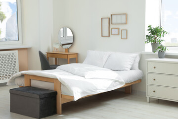 Bed with soft white pillows in cozy room interior