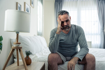Caucasian senior older depressed man sitting alone in bedroom at home. 