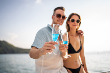 Caucasian young couple drinking champagne while having party in yacht. 
