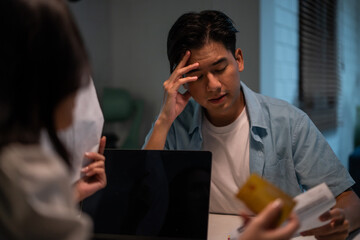 Asian young depressed couple having argument while checking money debt. 