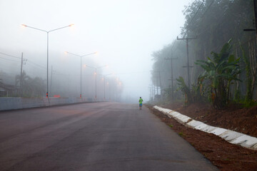 Fototapeta na wymiar The runner jogging easily on the road in early morning