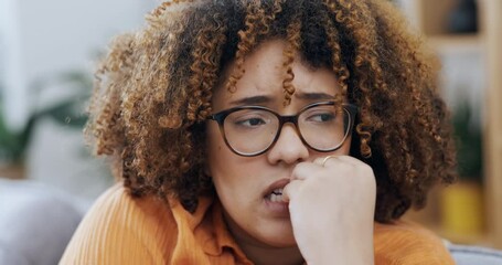 Anxiety, worry and nail biting by black woman on a sofa with fear, panic and mental health problem in her home. Stress, fear and girl with phobia, bad and habit on a couch with panic attack or scared