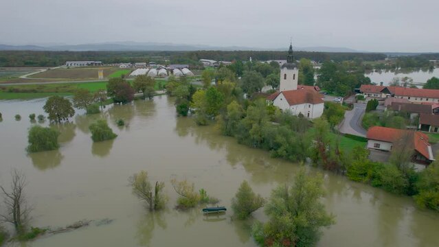 AERIAL: Flooded area around a small rural town after a swollen river overflowed. Muddy floodwater came dangerously close to the residential buildings and almost flooded bridge after heavy autumn rain