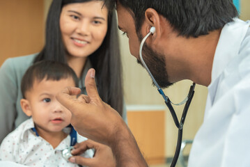 pediatrician hold stethoscope exam child boy patient with mother, black pediatrician seduce by toy kid pediatric checkup in hospital children medical care