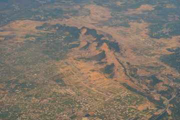 Aerial top view of paddy rice terraces, green agricultural fields in countryside, mountain hills valley, Thailand. Nature landscape. Crops harvest. View from airplane