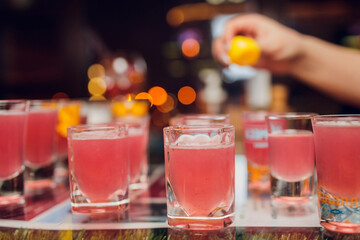 Variation of hard alcoholic shots served on bar counter. Blur bottles on background.