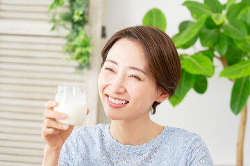 家で牛乳を飲む女性