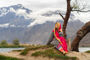 A Pakistani woman tourist travel in Karakoram high mountain hills. Nature landscape background, Skardu-Gilgit, Pakistan. Travel on holiday vacation. People lifestyle.