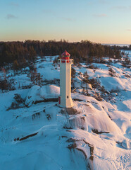 Snowy aerial drone view of Povorotny lighthouse, Vikhrevoi island, Gulf of Finland, Vyborg bay, Leningrad oblast, Russia, winter sunny day with a blue sky, lighthouses of Russia travel