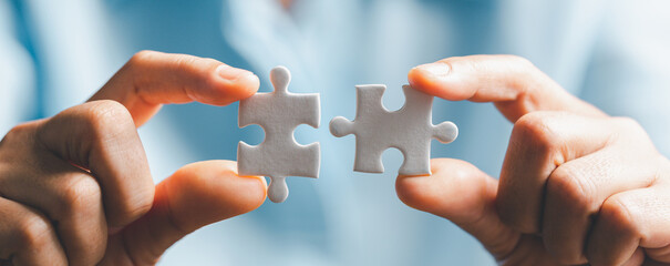 Business woman person hand holding puzzle piece idea for strategy and solution. Closeup part of two white jigsaw connect together. Concept of join cooperation success teamwork-problem corporate team - obrazy, fototapety, plakaty
