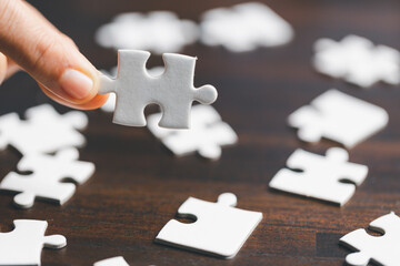 Business woman person hand holding puzzle piece idea for strategy and solution. Closeup part of one white jigsaw connect together. Concept of join cooperation success teamwork-problem corporate team