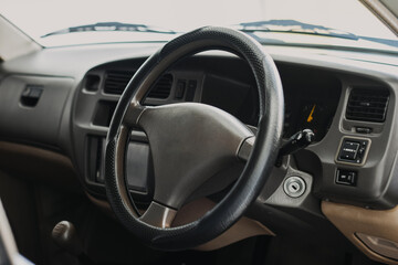 Obraz premium Black classic car interior. Steering wheel, speedometer, display and multimedia dashboard. Detail of car interior inside. Manual gear stick.