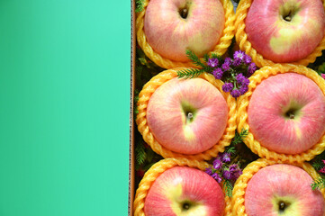 beautiful pink apple in the box on green background