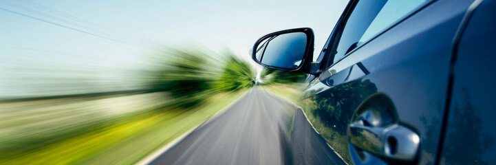 car on the road with motion blur background. Panoramic view with text space - obrazy, fototapety, plakaty