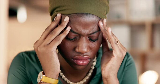 Headache, stress and burnout with a business black woman suffering from tension while working in her office. Anxiety, mental health and pain with a female employee rubbing her temples in discomfort