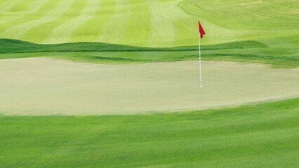 green putting with red flag in golf course