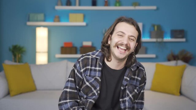 The man looking at the camera and laughing. Positive, gestures.
The man is laughing and happy. Positive mood.
