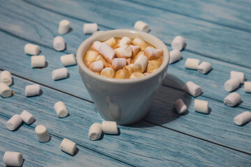 Close up of Cup hot chocolate marshmallows cacao. Cozy Coffee with marshmallows on wooden blue...