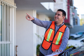 Engineer working on a construction with a vest pointing to the air