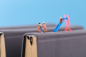 Miniature photography on books of children playing in primary school education