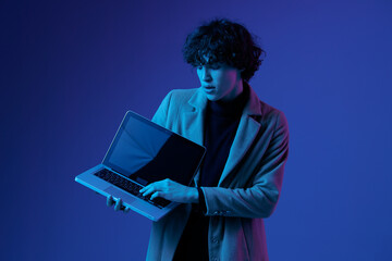 A man with a laptop in his hands and a jacket, smile, glasses in blue light, Blue Perennial color,...