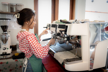 Beautiful asian coffee  girl barista working with coffee machine with smile in coffee shop.