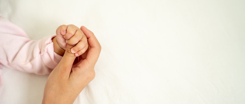 Asian Baby Hand in mother's hands that mean symblo of love. Mom and her Baby Child. Happy Family concept. Beautiful conceptual image of Mother and newborn baby family