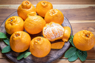 Fresh Orange fruit on Wooden table, Dekopon orange or sumo mandarin tangerine on wooden background.