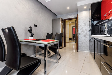 Modern kitchen interior with red and black cabinets and white ceramic floor