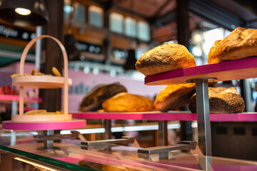 Bakery showcase with shelves and breads of various types exposed for sale to the public, Mercado de San Miguel, Madrid.