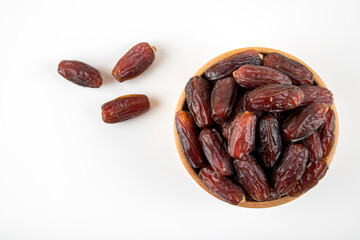 Date fruits in wooden bowl,on white background,top view