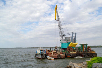 Fototapeta na wymiar Luffing crane at the barge on water