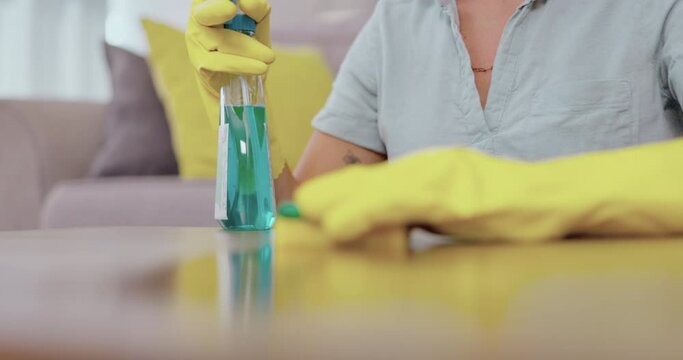 Woman, hands and detergent for housekeeping wiping table to clean surface, sanitize or disinfection at home. Hand of female cleaner or maid washing counter with spray bottle or sanitizer for hygiene